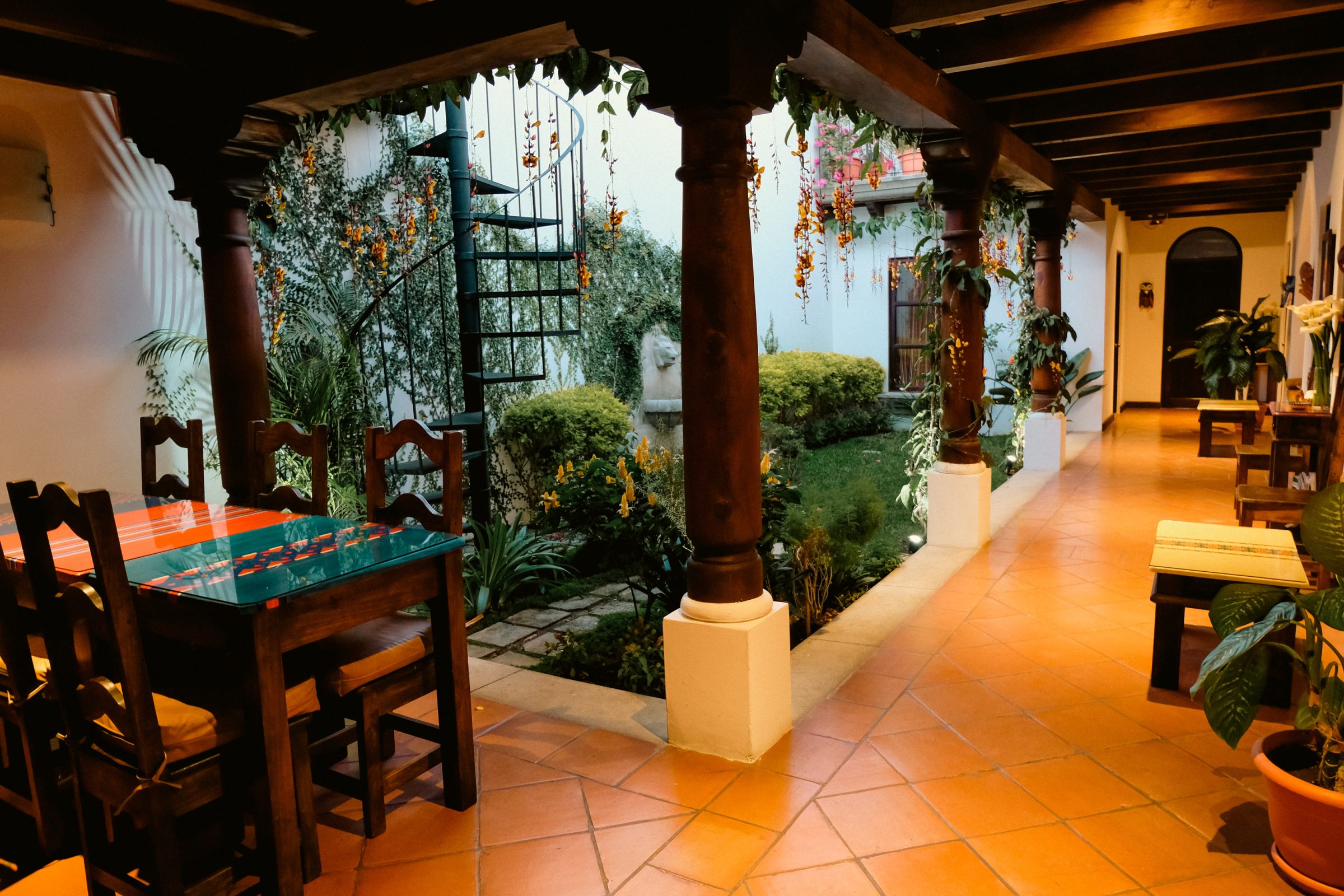 De ontbijttafel (links) met het trapje naar het dakterras vanaf de binnentuin | Casa Elena, Antigua