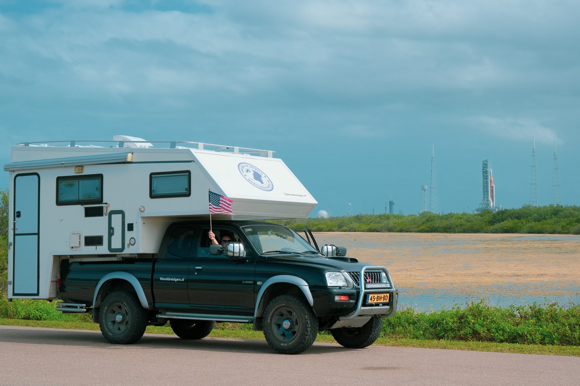 Onze 4x4 camper met een ruimteraket op de achtergrond bij het Kennedy Space Center