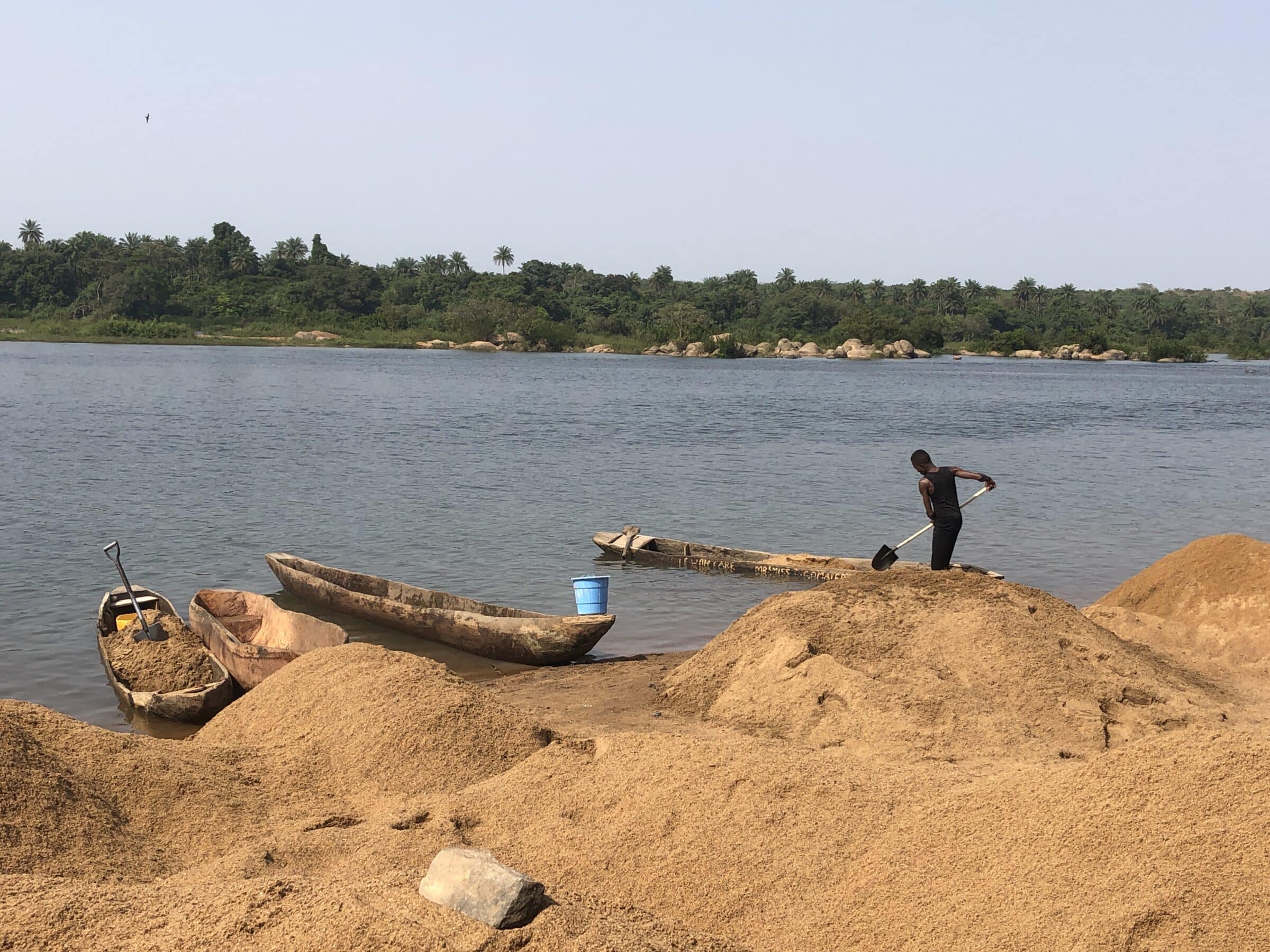 De kano met zand leegscheppen