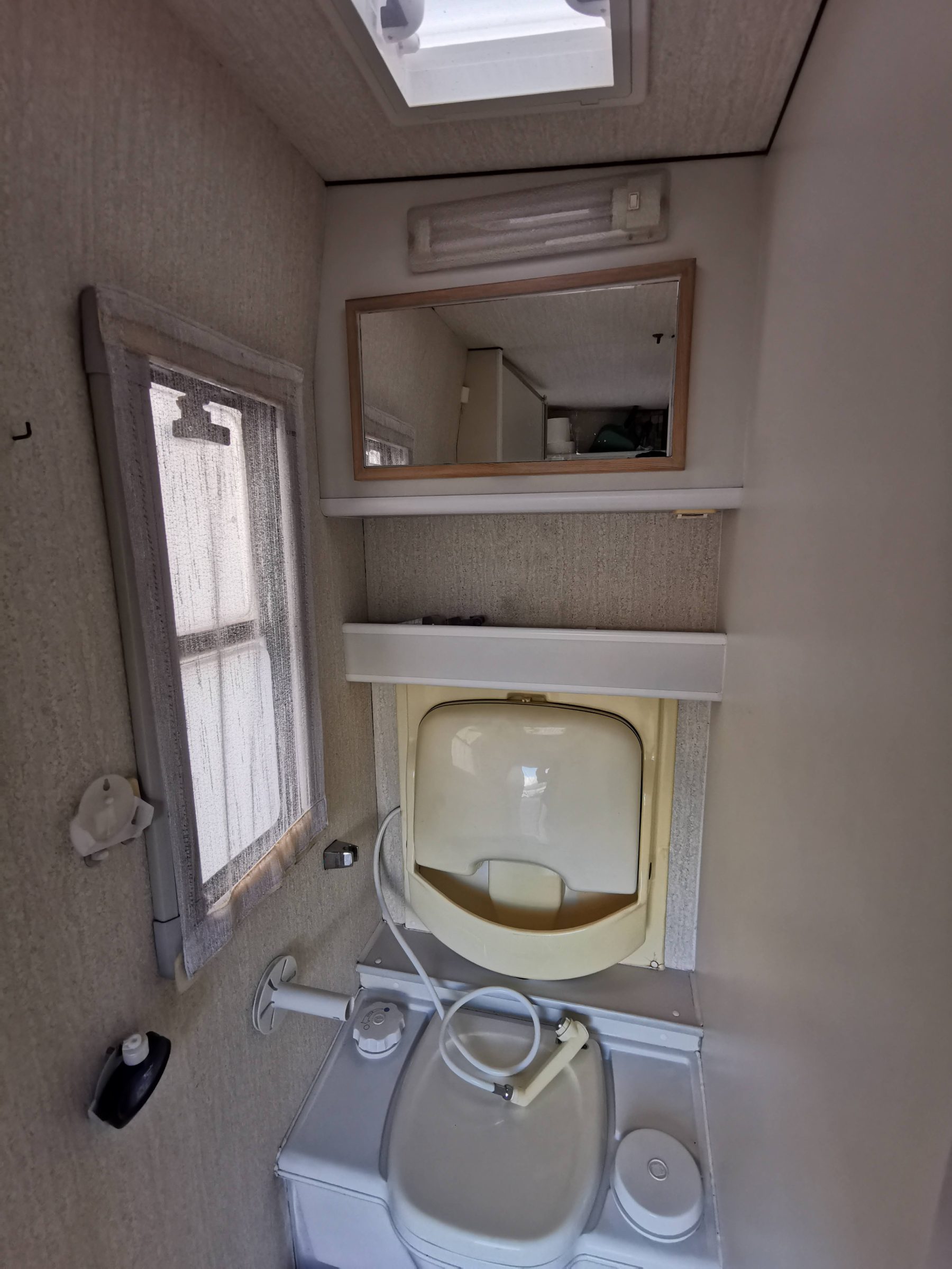 De badkamer / douchecabine in de camper voordat we begonnen - met de zeer gedateerde klap-wasbak