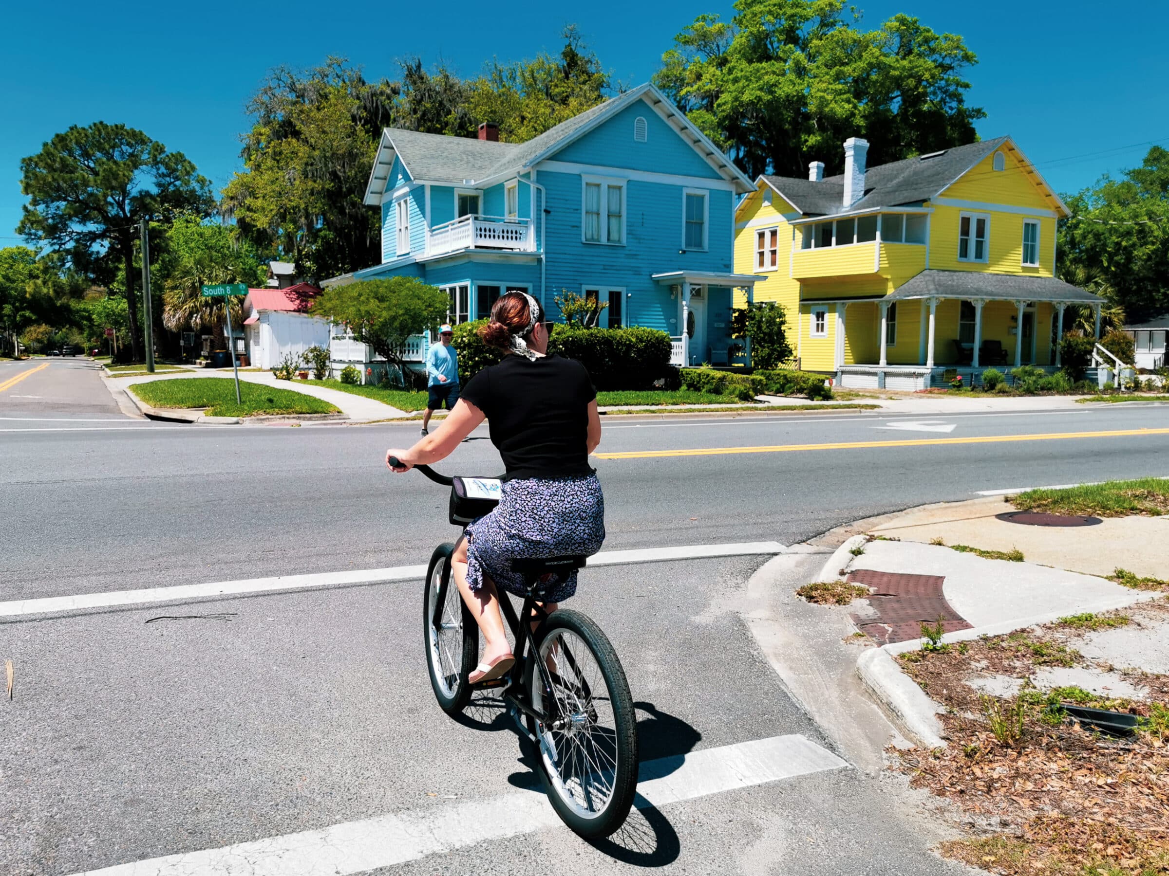 Malou fietst door één van de groene straten van Amelia City