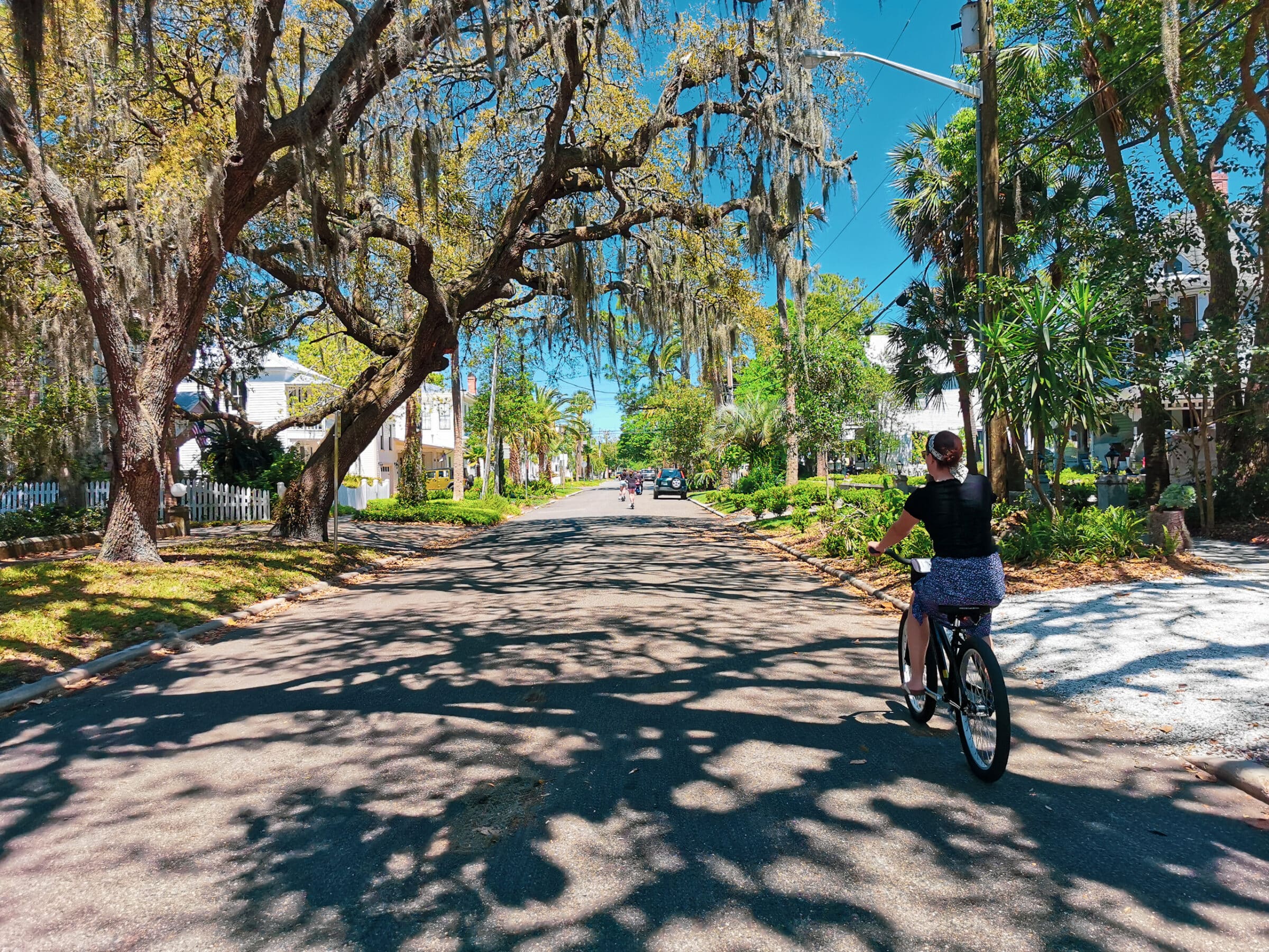 Malou fietst door één van de groene straten van Amelia City