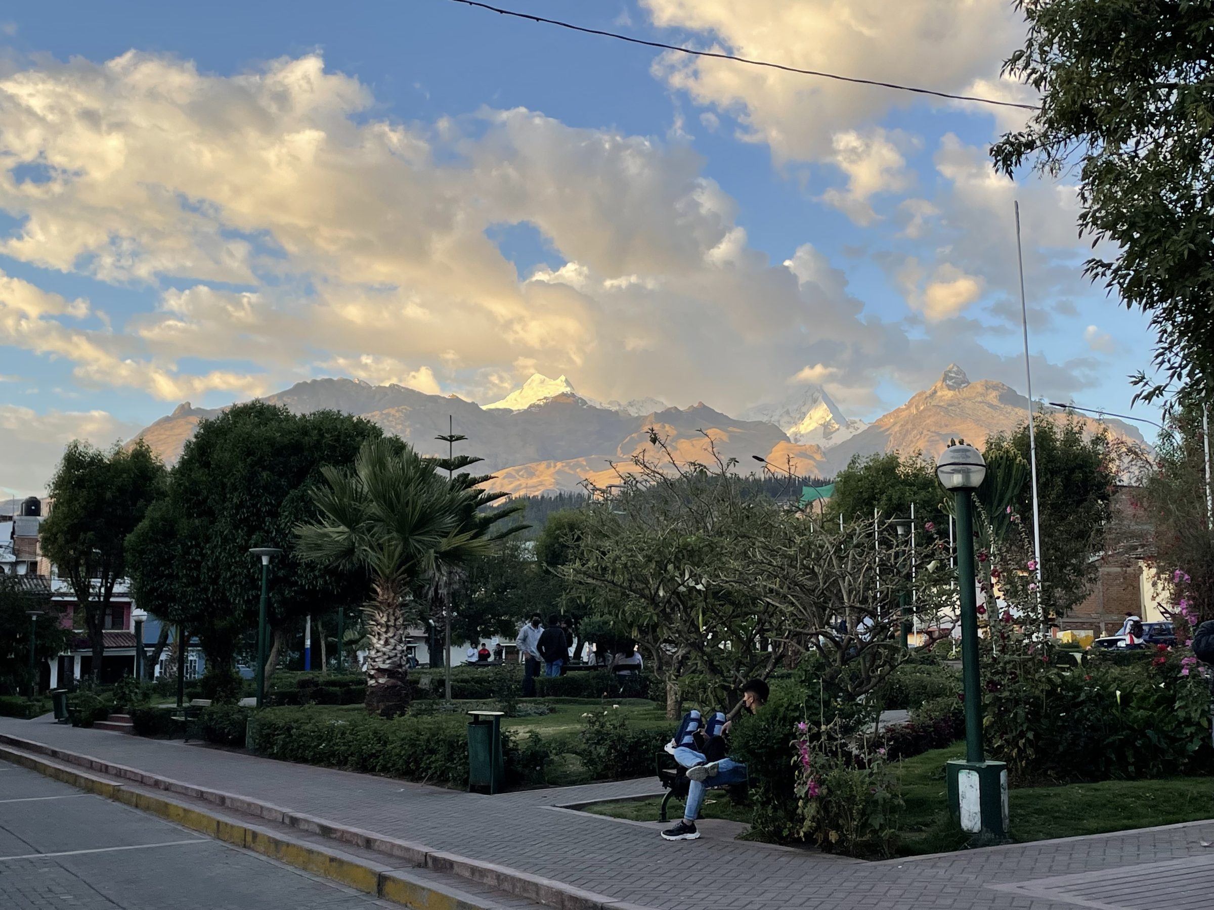 Una imagen tranquila de una ciudad agitada con un sol poniente en las montañas | Senderismo en Huaraz