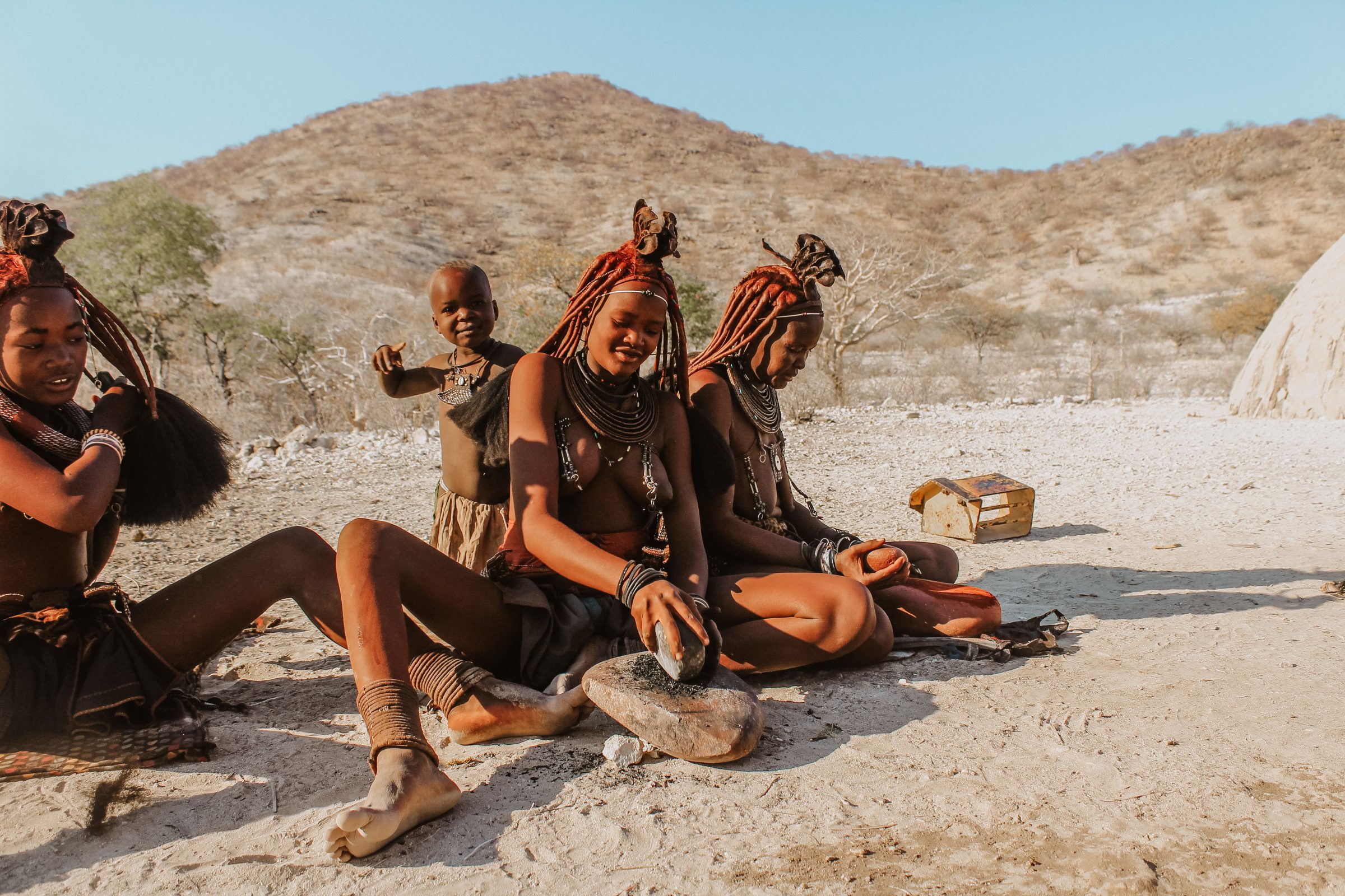 Himba vrouwen met de typische rood/oranje huidskleur door ochre