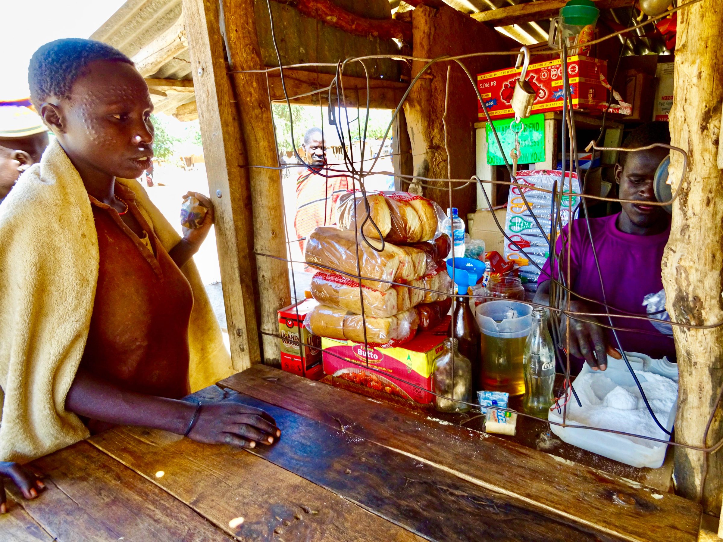 Karamajong vrouw koopt meel in winkel in Lopei | Karamoja | Wereldreizigers.nl