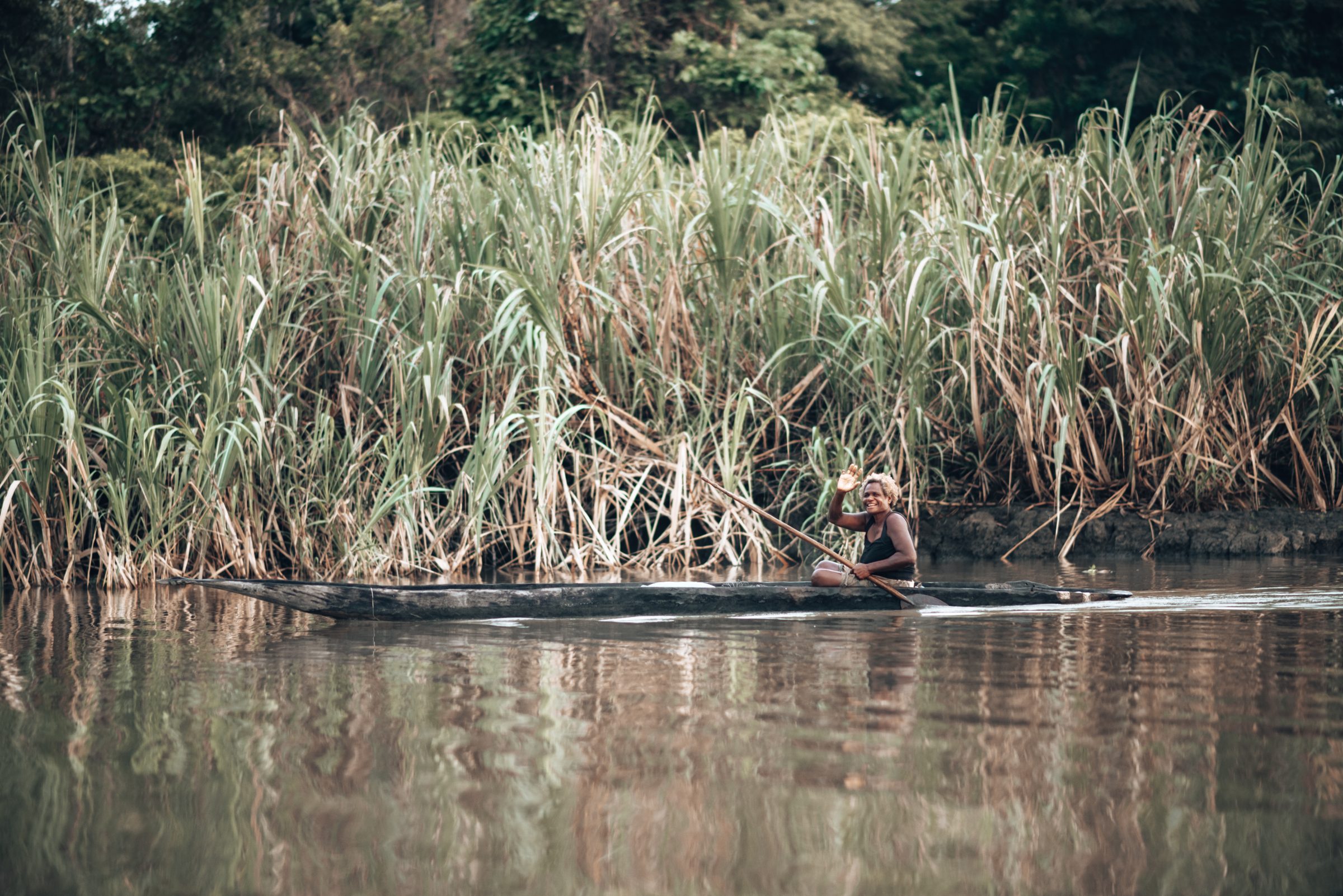 Vrouw in kano op weg om te vissen.